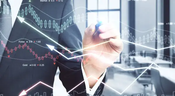 Biznesmen rysuje wykresy giełdowe i analizuje dane finansowe.