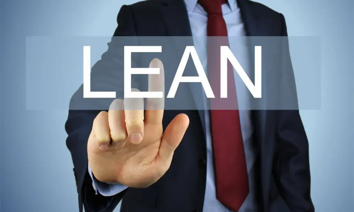 Biznesmen w garniturze dotyka ekranu z napisem "LEAN".
