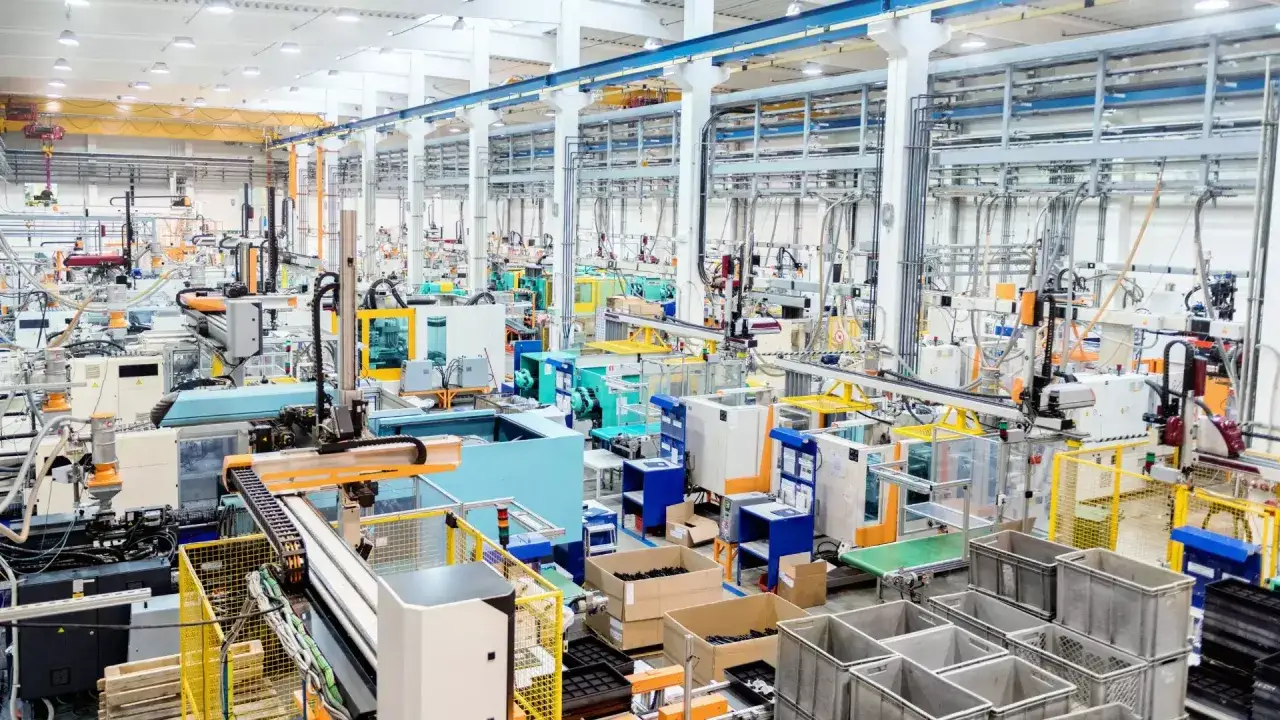 Nowoczesna hala produkcyjna z maszynami i taśmociągami, elementami systemu zarządzania produkcją.