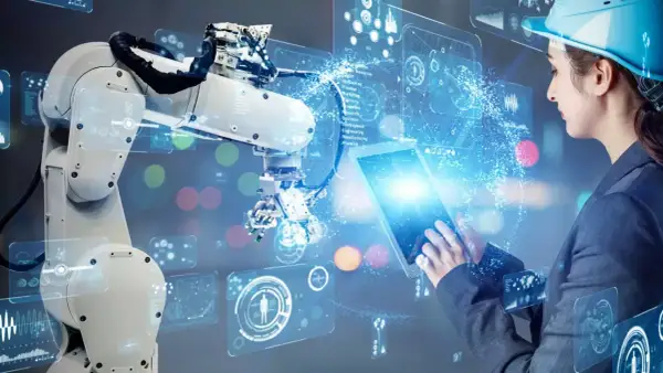 Inżynierka steruje robotem przemysłowym za pomocą tabletu, wizualizując dane w technologii **przemysł 5.0**.
